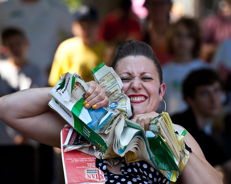 A woman tearing a thick book in half with her hands